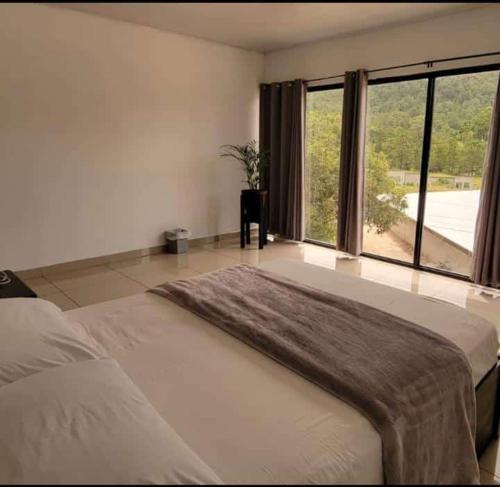 a bedroom with a large bed with a large window at Diesbu Hotel in Marcala