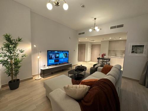 a living room with a couch and a flat screen tv at Hala homes @Yas Island-1BR in Abu Dhabi