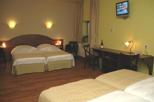 a hotel room with two beds and a television at Hotel Van Reeth's Koffiebranderij in Puurs