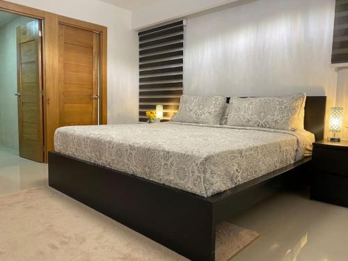 um quarto com uma cama grande e uma parede de madeira em Stylish Apt Full AC King Bed em Los Prados