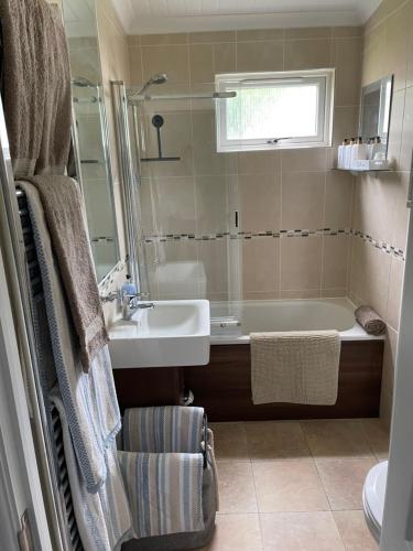 a bathroom with a bath tub and a sink at Quince in Ferndown
