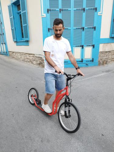 a man riding a red bike in the street at Lazaros Stonehouse in Pano Lefkara