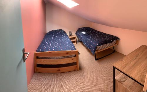 une chambre avec deux lits superposés et une table dans l'établissement Centre de bien-être Naturéau avec massages et soins, à Chalandray