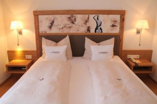 a bedroom with a large bed with white sheets and pillows at Garden & SPA Hotel Das Götzfried in Regensburg