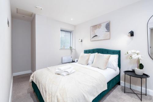 a bedroom with a large bed with a green headboard at The Stylish Spot 1 Bed Apt in Leeds City Centre in Leeds