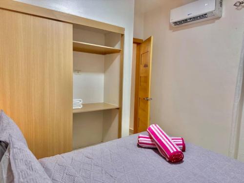 a pink suitcase sitting on a bed in a room at Cozy Hideaway Apt Near Beach in Boca Chica