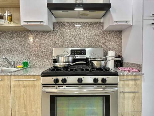 a kitchen with a stove with pots and pans on it at Cozy Hideaway Apt Near Beach in Boca Chica