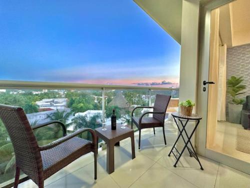 a balcony with chairs and a table with a view at Cozy Hideaway Apt Near Beach in Boca Chica