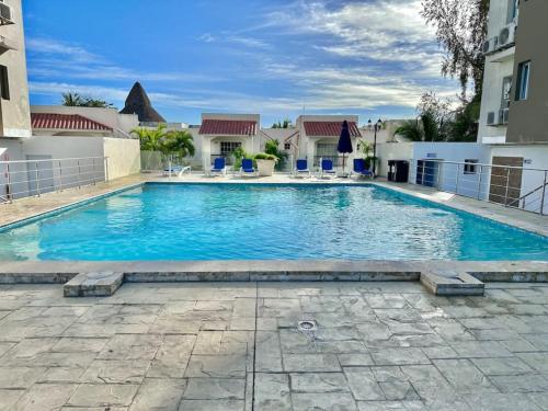 a large swimming pool with blue water in a courtyard at Cozy Hideaway Apt Near Beach in Boca Chica