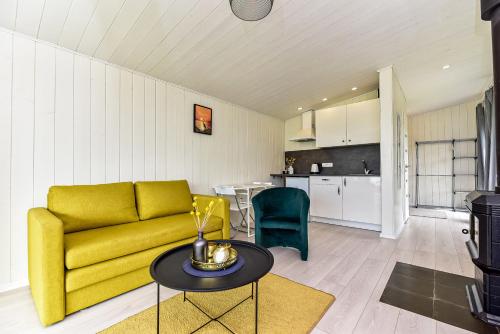 a living room with a yellow couch and a table at Volunge house in Doškonys