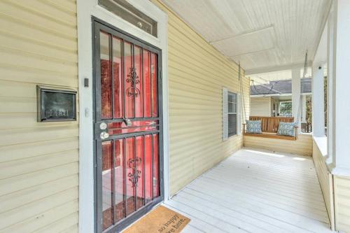 Bright & Charming Cooper Young Cottage with Fire Pit and Porch Swing في ممفيس: باب احمر على جانب المنزل