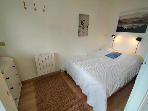 a bedroom with a white bed with a blue pillow at Appartement Avoriaz, 2 pièces, 4 personnes - FR-1-633-73 in Morzine