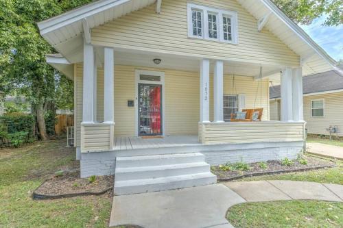 a yellow house with a porch and stairs in front of it at Bright & Charming Cooper Young Cottage with Fire Pit and Porch Swing in Memphis