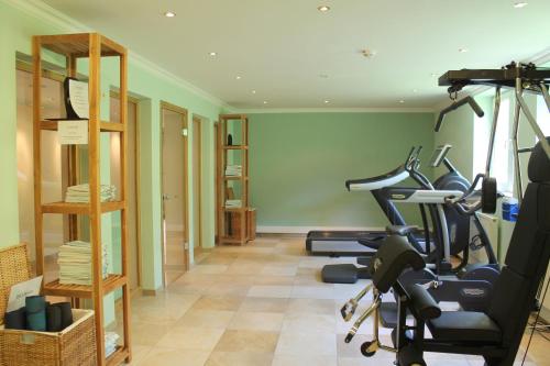 a gym with treadmills and exercise bikes in a room at Garden & SPA Hotel Das Götzfried in Regensburg