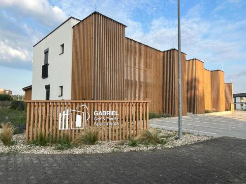 un edificio con una valla de madera delante de él en Meet & Golf, en Šajdíkove Humence