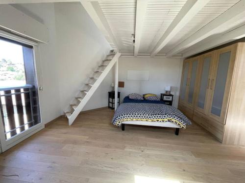 - une chambre avec un lit et un escalier dans l'établissement Séjour idyllique, à Annecy