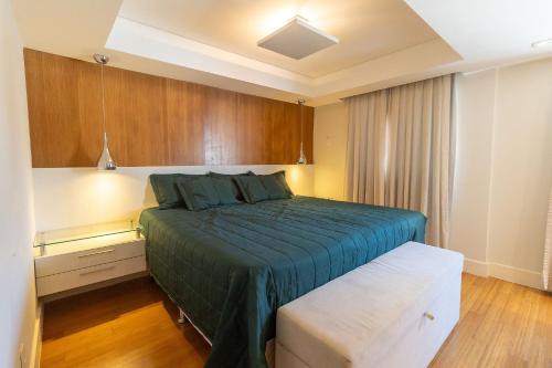 1 dormitorio con 1 cama con colcha azul en Porto Canoas 203 - Aconchegante apartamento em Bombas - Acomoda 4 pessoas - À poucos metros da praia, en Bombinhas