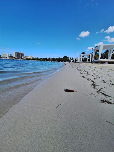 a beach with footprints in the sand and the water at Beach One Bedroom 2 in Ocho Rios