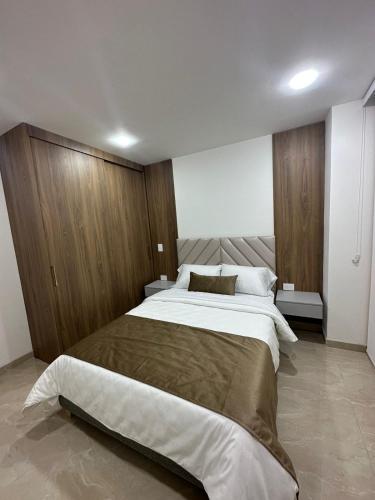 a bedroom with a large bed and wooden cabinets at Mar Apartamentos in Bucaramanga