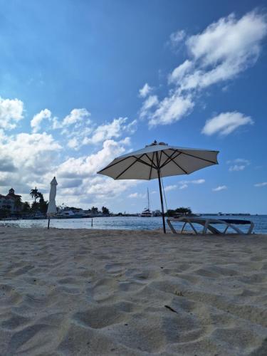 a picnic table and an umbrella on the beach at Beach One Bedroom 2 in Ocho Rios
