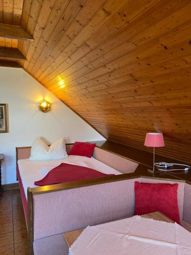 two beds in a room with a wooden ceiling at Landhaus GRETE in Stubenberg
