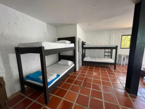 a room with two bunk beds and a tile floor at Hotel Campestre La María Toro Valle in Toro