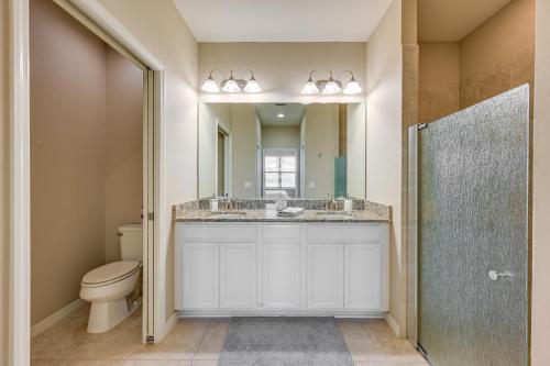 W łazience znajduje się toaleta, umywalka i lustro. w obiekcie Chic Country Club Condo with Upscale Amenities w mieście Bonita Springs