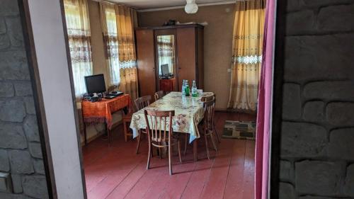 uma sala de jantar com uma mesa e cadeiras e uma televisão em Guest house 