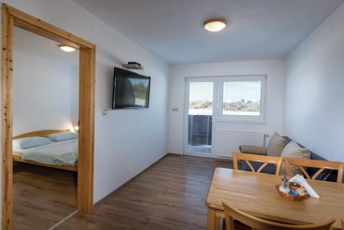 a room with a bed and a dining room with a table at Rezidencia Podhájska in Podhájska
