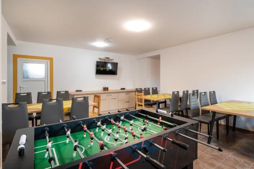 a room with a ping pong table and chairs at Rezidencia Podhájska in Podhájska