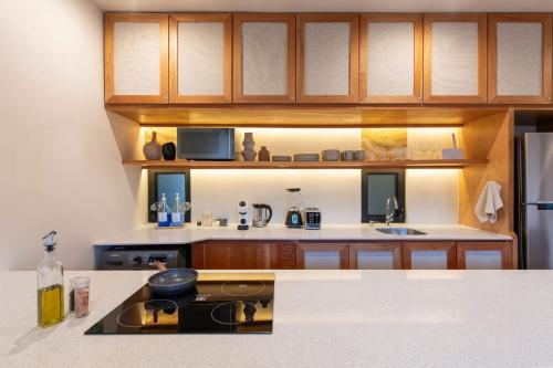 a kitchen with wooden cabinets and a counter top at Nibana departamento de lujo en Mérida, Planta baja in Mérida