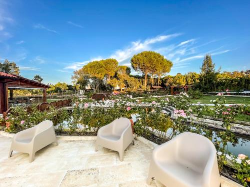 three white chairs in a garden with flowers at Quinta do Cutato - Beatriz Guest House - Sotão in Santo Estêvão