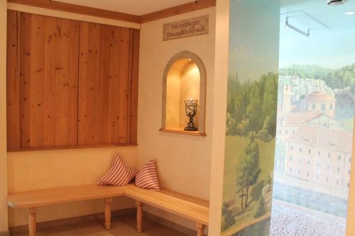 a bench in a room with a painting on the wall at Garden & SPA Hotel Das Götzfried in Regensburg