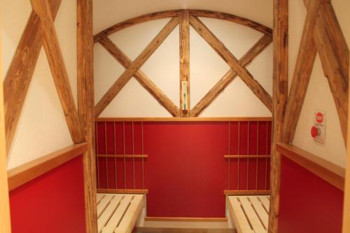 a room with red walls and wooden beams at Garden & SPA Hotel Das Götzfried in Regensburg