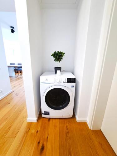 a plant on top of a washing machine in a room at Prestigious SKY PARK apartment - top city view - Traveller awards 2024 in Bratislava