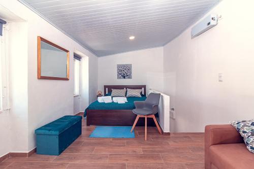 a bedroom with a bed and a chair and a couch at Casa do Largo de NaturAlegre in Alegrete