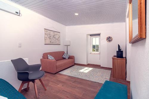 a living room with a couch and a chair at Casa do Largo de NaturAlegre in Alegrete