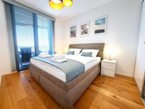 a bedroom with a large bed and a large window at Prestigious SKY PARK apartment - City view - Traveller awards 2024 in Bratislava