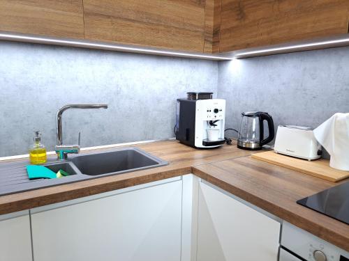 a kitchen counter with a sink and a coffee maker at Prestigious SKY PARK apartment - top city view - Traveller awards 2024 in Bratislava