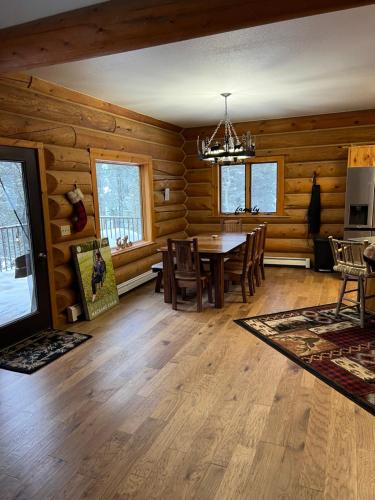 una sala da pranzo con tavolo in una baita di tronchi di Cerul Mare Cabin a Gallatin Gateway