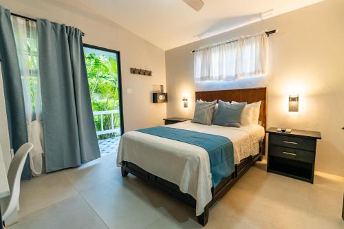 Travellers Beach Resort في نيغريل: غرفة نوم بسرير ونافذة كبيرة