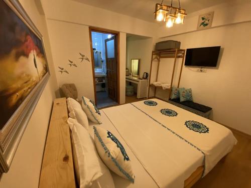 1 dormitorio con 1 cama blanca grande en una habitación en Sığacık Duru Pansiyon, en Seferihisar