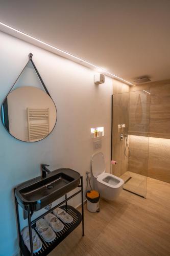 a bathroom with a toilet and a sink and a mirror at North Alpine Villas in Bogë