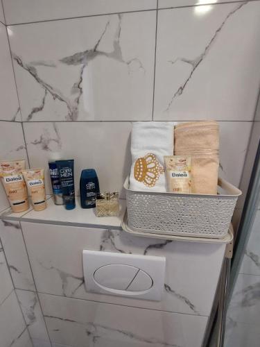 uma prateleira de casa de banho com toalhas e outros produtos em Apartman Stevanovic Zlatibor em Zlatibor