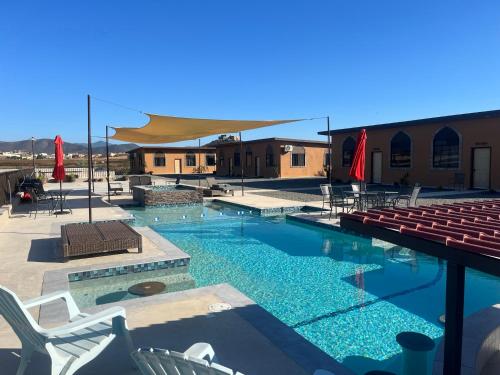 a swimming pool with chairs and tables and chairs at Villas Persas by Jardin de Persia in Valle de Guadalupe