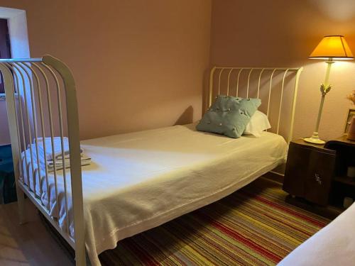 un letto in una stanza con una culla con una lampada di Casa Pero Soares a Guarda