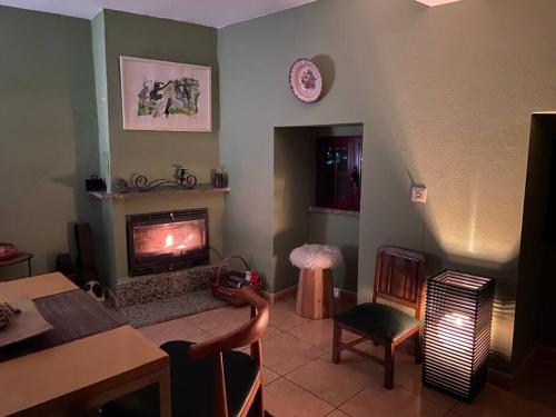 un soggiorno con camino, tavolo e sedie di Casa Pero Soares a Guarda