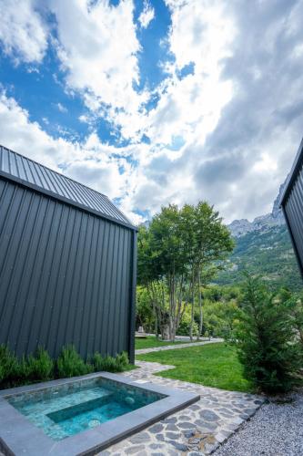 a backyard with a swimming pool next to a building at North Alpine Villas in Bogë