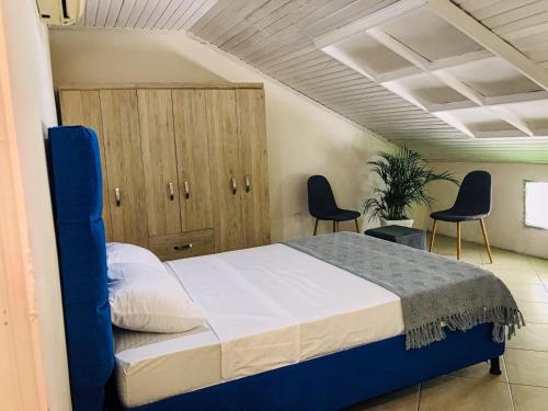 um quarto com uma cama com 2 cadeiras e armários em Casa Hotel Terraza del Cabrero em Cartagena de Indias