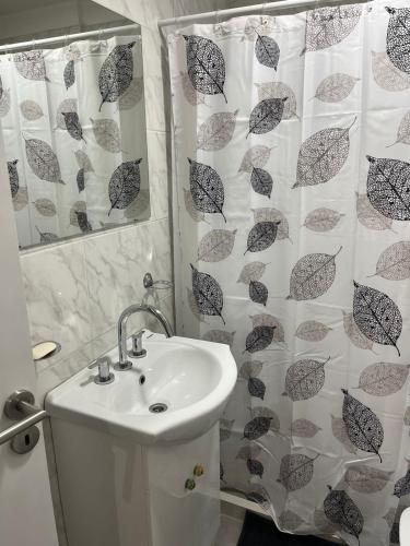 a bathroom with a sink and a shower curtain at Ministro Brin Suite MT in Remedios de Escalada